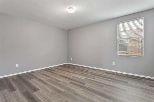 unfurnished room featuring baseboards and wood finished floors