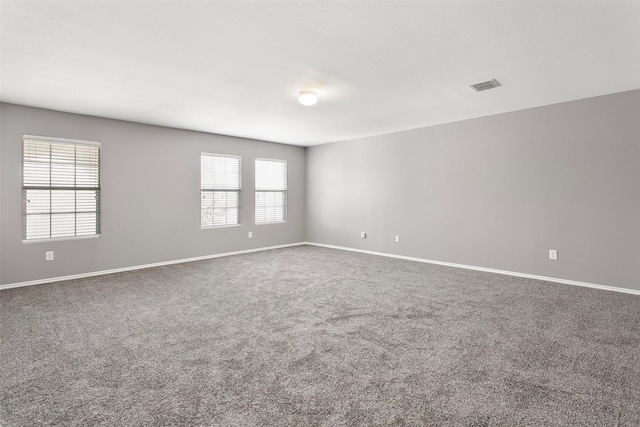 unfurnished room featuring visible vents, baseboards, and carpet