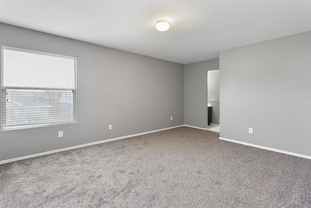 carpeted empty room with baseboards