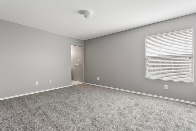 spare room with carpet flooring and baseboards