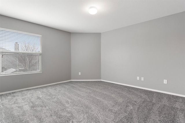 carpeted spare room featuring baseboards