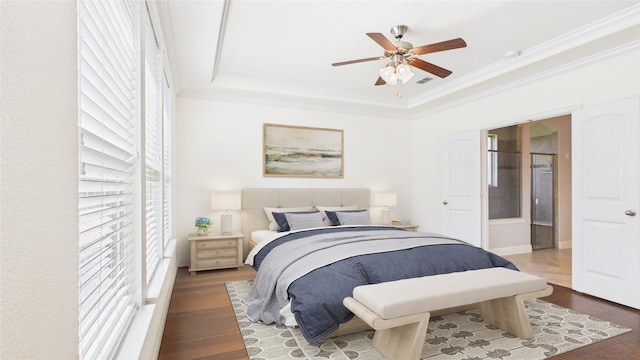 bedroom featuring visible vents, a raised ceiling, ceiling fan, wood finished floors, and crown molding