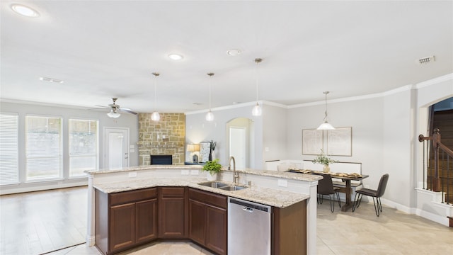 kitchen featuring ornamental molding, open floor plan, a sink, and stainless steel dishwasher