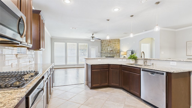 kitchen with a sink, a ceiling fan, ornamental molding, appliances with stainless steel finishes, and decorative backsplash