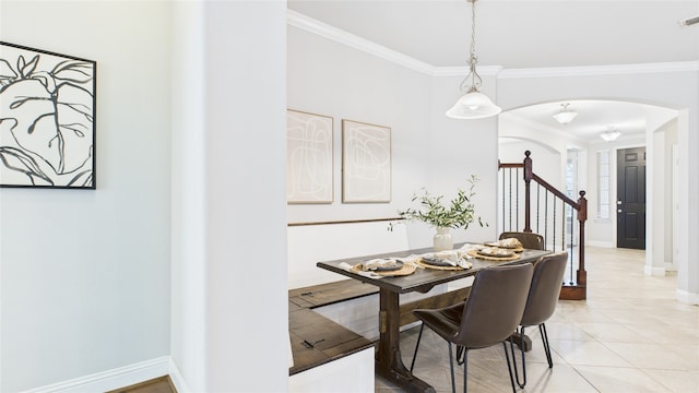 dining area with arched walkways, light tile patterned floors, baseboards, and crown molding