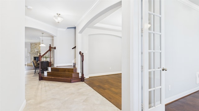 entrance foyer featuring ornamental molding, stairs, baseboards, and wood finished floors