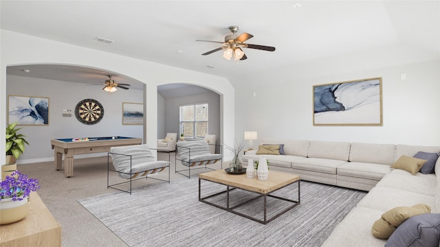 carpeted living room featuring arched walkways, visible vents, a ceiling fan, billiards, and baseboards