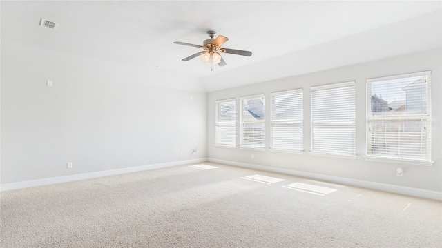 spare room with baseboards, visible vents, ceiling fan, and light colored carpet