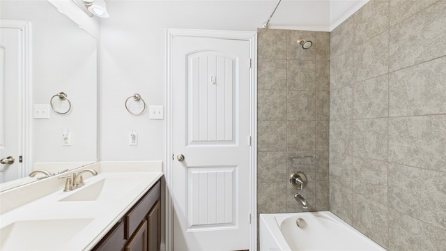 bathroom with double vanity, shower / tub combination, and a sink