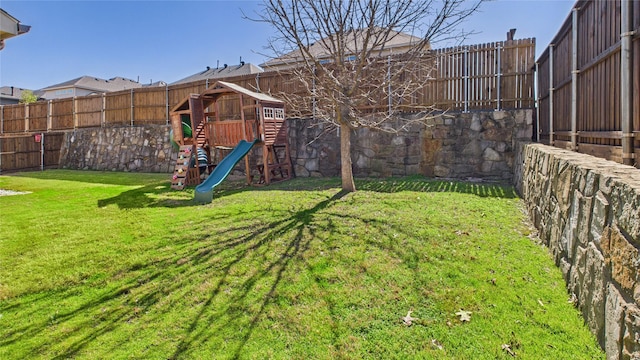 view of yard featuring a playground and a fenced backyard