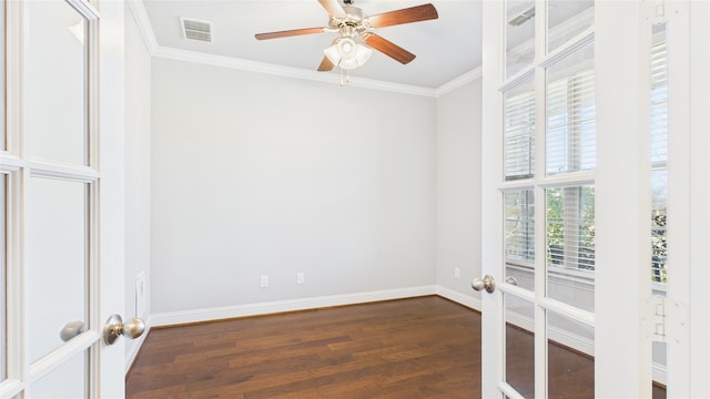 spare room featuring baseboards, visible vents, dark wood finished floors, and crown molding