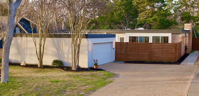 garage with fence and driveway