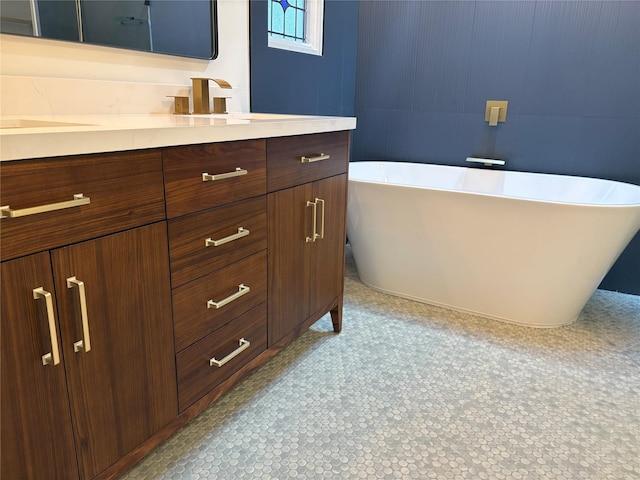 full bathroom featuring a soaking tub, vanity, and tile patterned floors