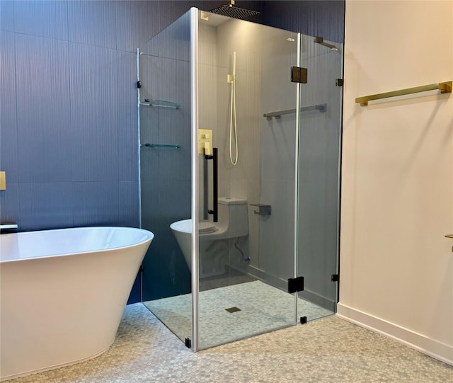 full bath featuring a stall shower, baseboards, and a freestanding bath