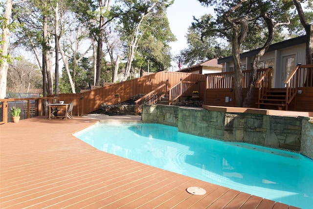 view of swimming pool with a fenced in pool, fence, a deck, and stairs