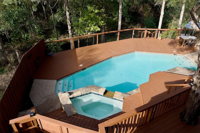 view of pool with a deck, a fenced in pool, and an in ground hot tub