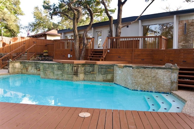 view of swimming pool featuring fence, stairway, a fenced in pool, and a wooden deck