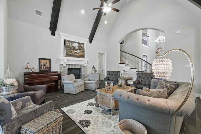 living room featuring visible vents, stairway, dark wood-type flooring, a fireplace, and high vaulted ceiling