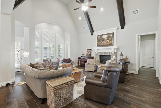 living room with baseboards, high vaulted ceiling, dark wood-style flooring, and a stone fireplace