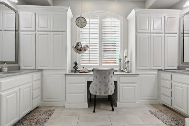 home office with light tile patterned floors, a sink, and built in study area