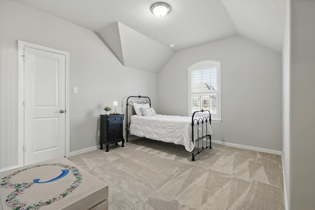 bedroom featuring lofted ceiling, baseboards, and light colored carpet