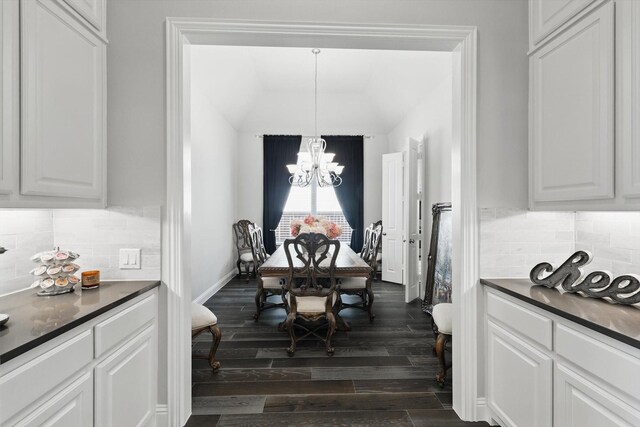 dining area with a chandelier, dark wood-style flooring, and baseboards