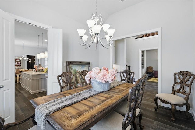 dining space featuring vaulted ceiling, dark wood finished floors, and an inviting chandelier