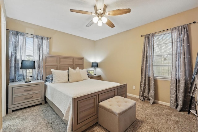 bedroom with light carpet, ceiling fan, and baseboards