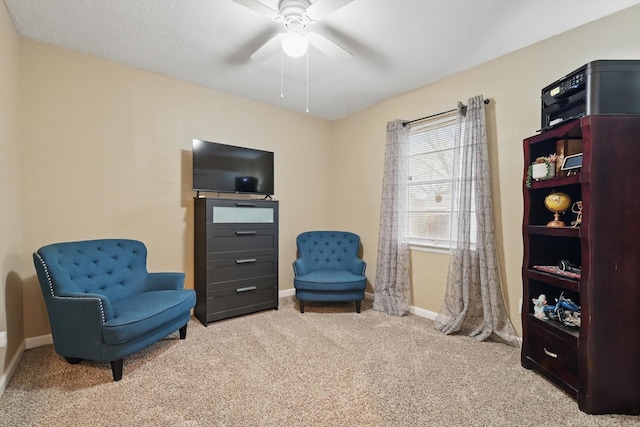 living area featuring carpet flooring, ceiling fan, and baseboards