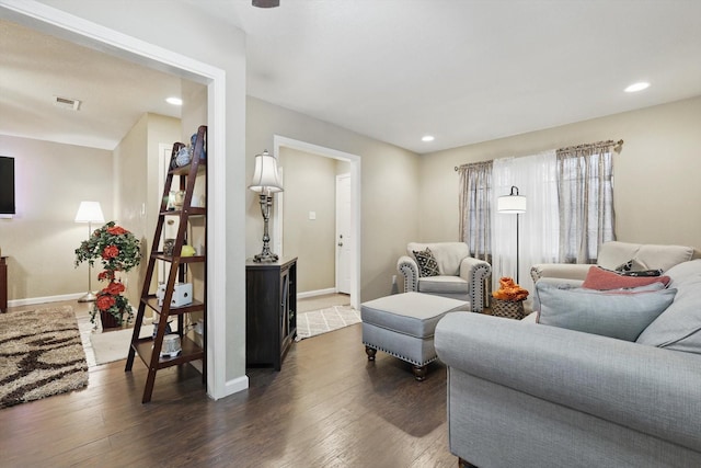 living room featuring dark wood-type flooring, recessed lighting, visible vents, and baseboards