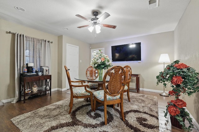 dining area featuring baseboards, wood finished floors, visible vents, and a ceiling fan