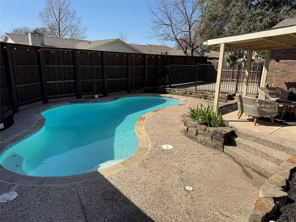 view of swimming pool featuring a fenced backyard, a fenced in pool, and a patio