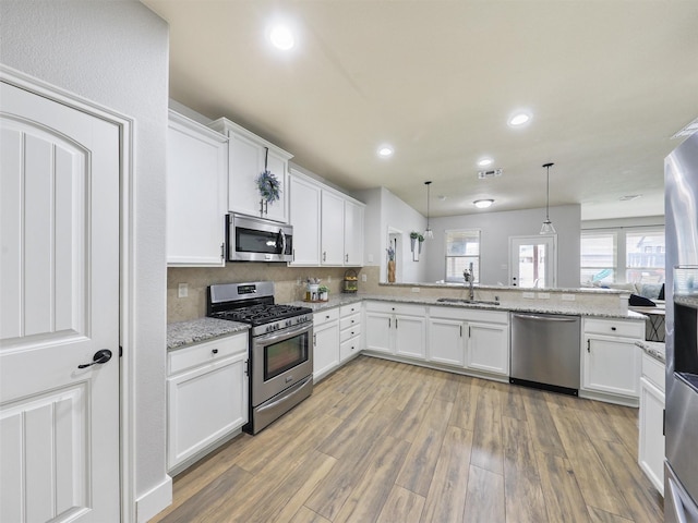 kitchen with visible vents, appliances with stainless steel finishes, light wood-type flooring, white cabinetry, and a sink