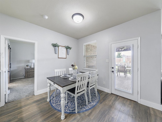 dining room featuring dark wood finished floors, a textured ceiling, and baseboards