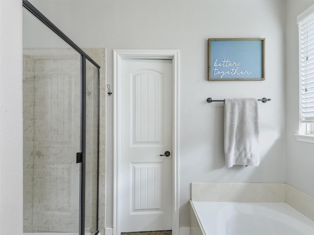 bathroom with a stall shower and a bath