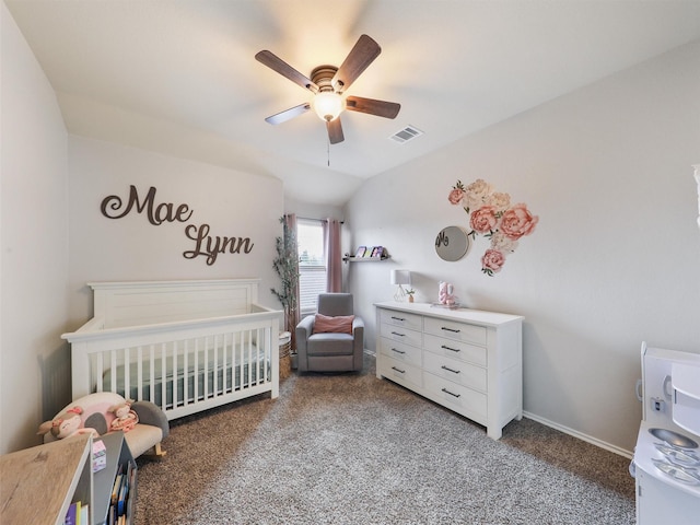 carpeted bedroom with visible vents, vaulted ceiling, ceiling fan, a crib, and baseboards