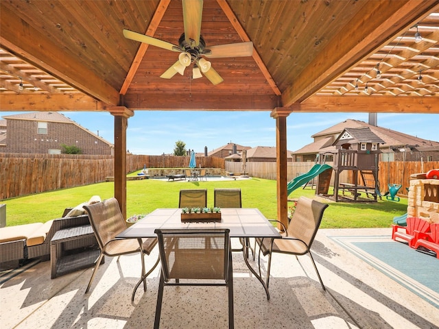 view of patio / terrace featuring a gazebo, a fenced backyard, a playground, and outdoor dining space