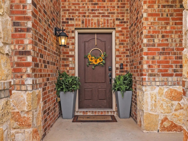 view of exterior entry featuring brick siding