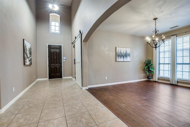 321 Westlake, Forney, TX 75126 - tiled entryway with a barn door, baseboards, stairs, arched walkways, and a high ceiling