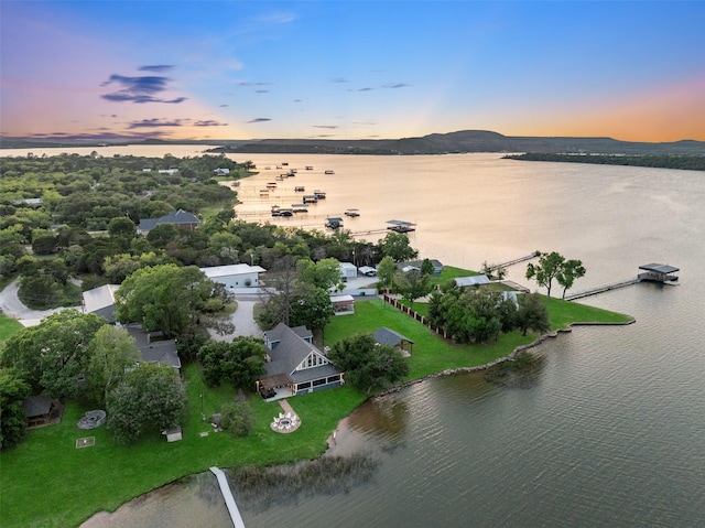 aerial view at dusk featuring a water view