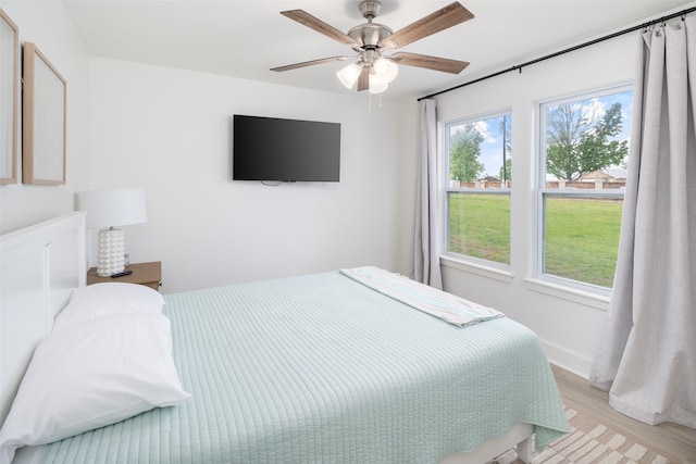 bedroom featuring light wood-style floors, ceiling fan, and baseboards