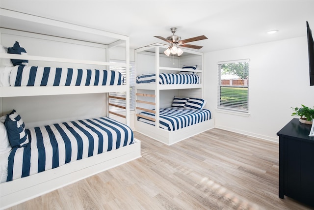 bedroom featuring ceiling fan, baseboards, and wood finished floors