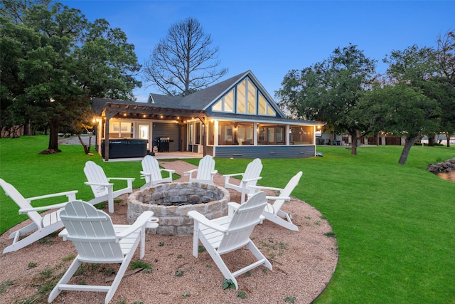 rear view of house featuring a patio, a fire pit, a sunroom, a pergola, and a hot tub