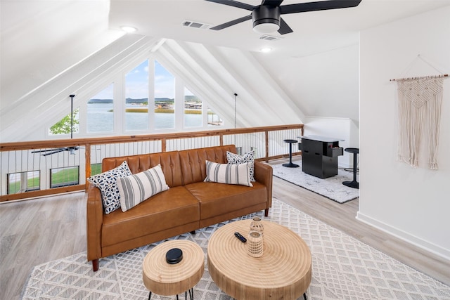 living area with lofted ceiling, visible vents, a water view, a ceiling fan, and wood finished floors