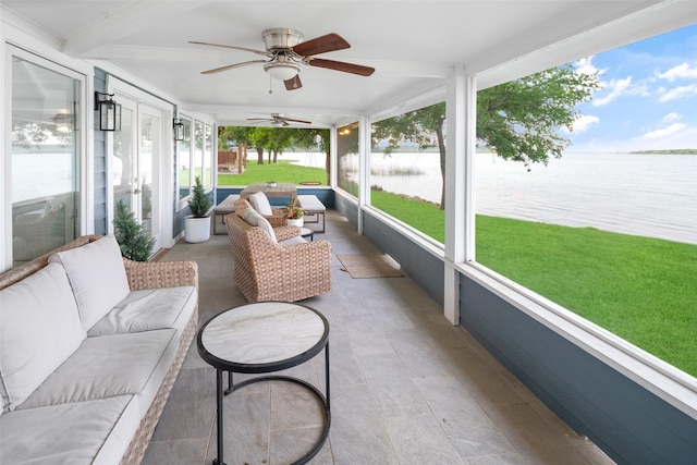 sunroom featuring a water view and a ceiling fan