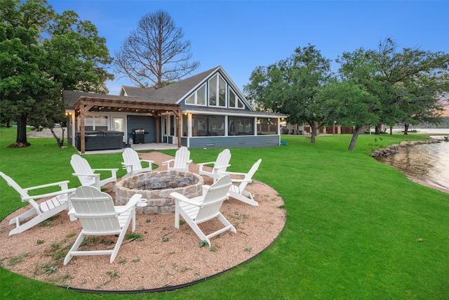 rear view of property with an outdoor fire pit, a lawn, a sunroom, a patio area, and a pergola