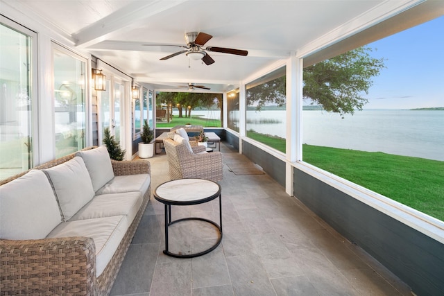 sunroom / solarium with a water view, ceiling fan, and beam ceiling