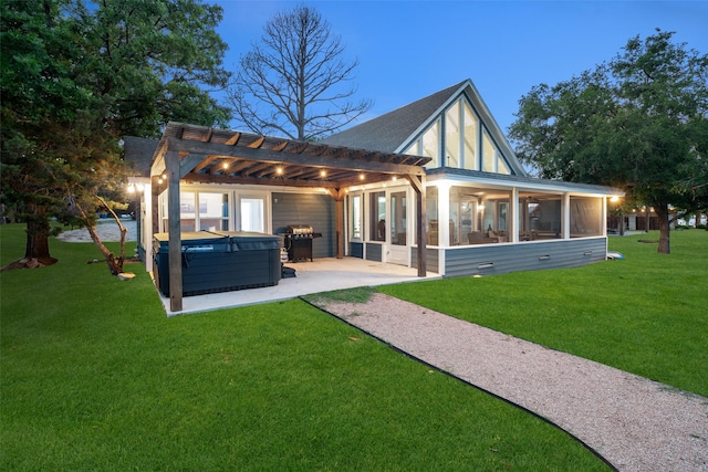 back of property with a sunroom, a lawn, a pergola, a patio area, and a hot tub