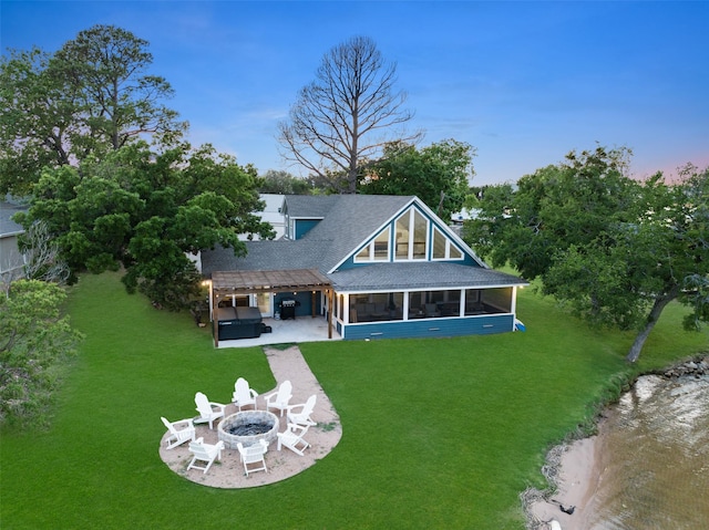 rear view of house featuring a fire pit, a lawn, a patio, a sunroom, and a pergola