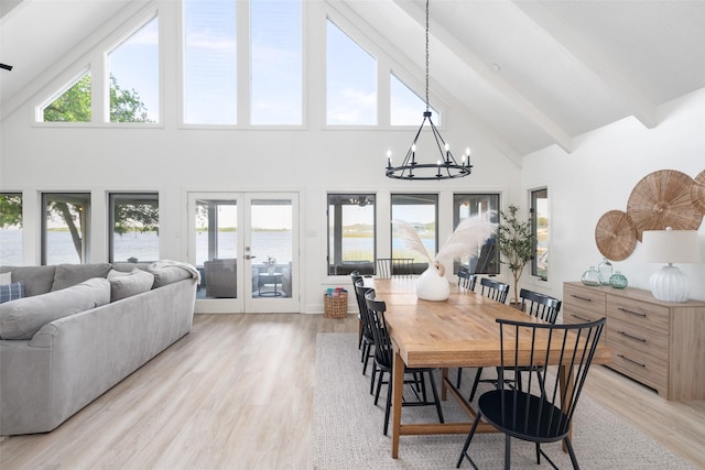 dining space with a wealth of natural light, light wood-style flooring, beamed ceiling, french doors, and a notable chandelier